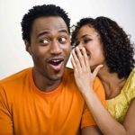 Woman whispering to man