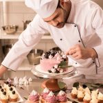 portrait of confectioner decorating cake in restaurant kitchen